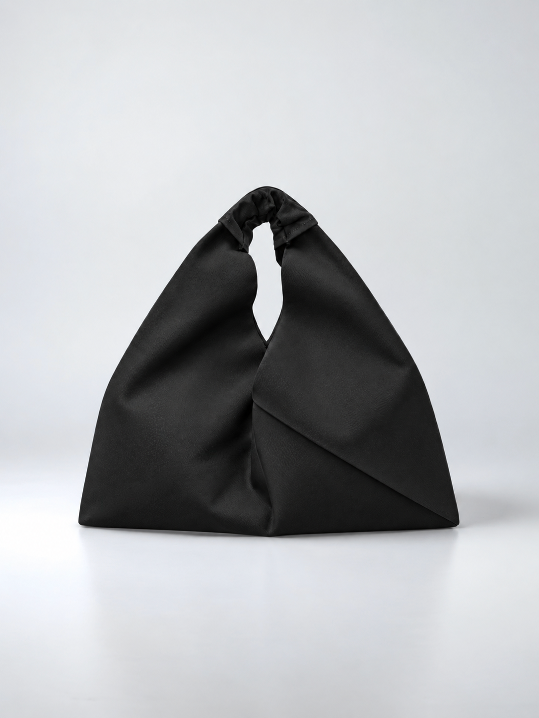 Black waxed canvas origami bag, by Esra Kayira. 